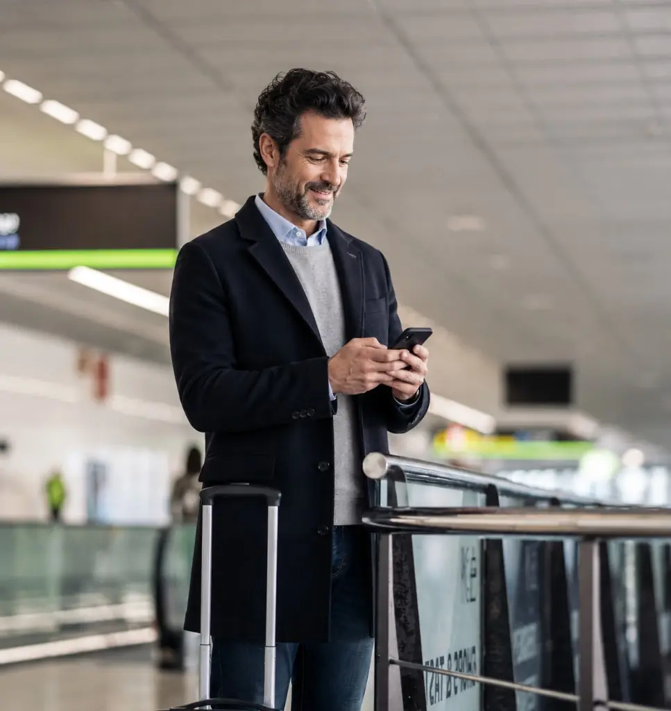 Traveller checking his Schengen visa appointment on his phone at the airport